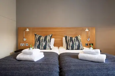two beds in a hotel room with towels on them at Apex City of Edinburgh Hotel in Edinburgh