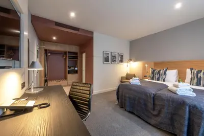 a hotel room with a large bed and a desk at Apex City of Edinburgh Hotel in Edinburgh