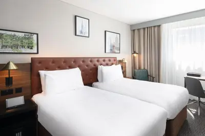 a hotel room with two beds and a desk at Four Points by Sheraton Edinburgh in Edinburgh
