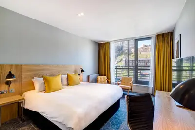 a hotel room with a bed and a large window at Apex Grassmarket Hotel in Edinburgh