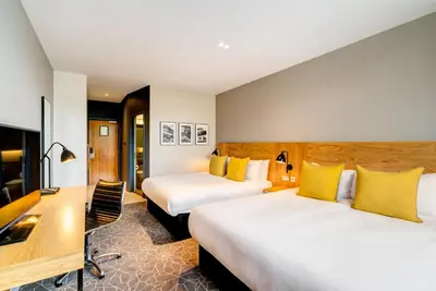 a hotel room with two beds and a desk at Apex Grassmarket Hotel in Edinburgh