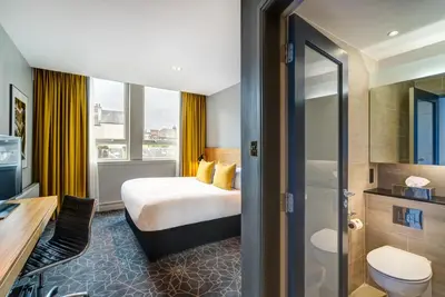 a hotel room with a bed and a bathroom at Apex Grassmarket Hotel in Edinburgh