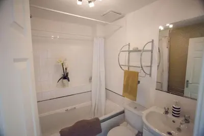 a white bathroom with a toilet and a sink at Glasgow Hampden House in Glasgow
