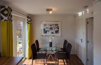 a dining room with a glass table and chairs at Glasgow Hampden House in Glasgow