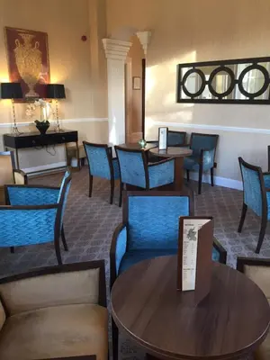 a waiting room with blue chairs and tables at Garvock House Hotel in Dunfermline