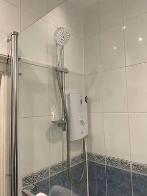 a shower with a shower head in a bathroom at The Lothian Road Residence in Edinburgh