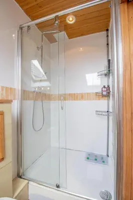 a shower with a glass door in a bathroom at Almada Apartment in Hamilton
