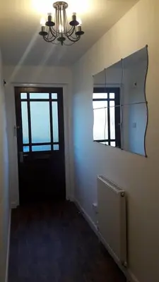 a hallway with a mirror and a black door at Sunnyside Apartments in Coatbridge