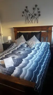 a bed with a blue and white comforter at Sunnyside Apartments in Coatbridge