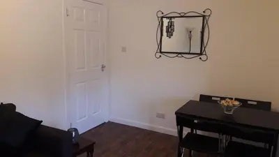a room with a table and a door and a table and chairs at Sunnyside Apartments in Coatbridge