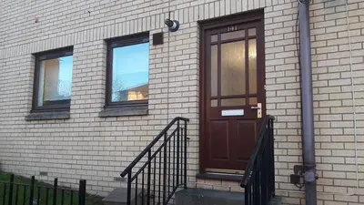 a brown door on the side of a brick building at Sunnyside Apartments in Coatbridge