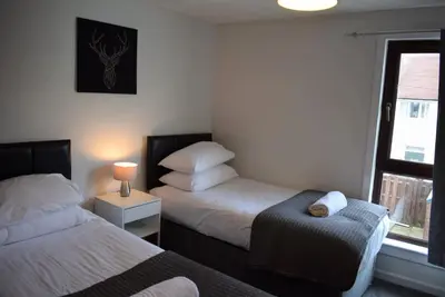 a bedroom with two beds and a window at 3 Bedroom-Kelpies Serviced Apartments Bruce in Falkirk