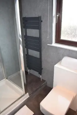 a bathroom with a toilet and a glass shower at 3 Bedroom-Kelpies Serviced Apartments Bruce in Falkirk