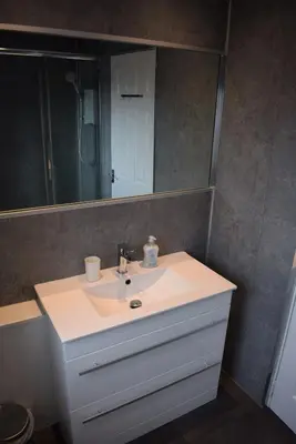 a bathroom with a white sink and a mirror at 3 Bedroom-Kelpies Serviced Apartments Bruce in Falkirk