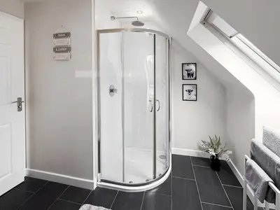 a glass shower in a bathroom with a staircase at The Snug in Harthill