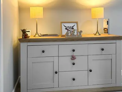 a white dresser with two lamps on top of it at The Snug in Harthill
