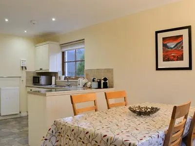 a kitchen with a table and chairs and a table and a table andheasternheastern at Taigh Seonaig in Glencoe