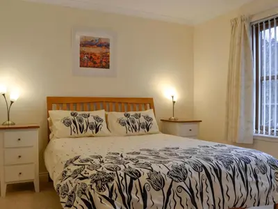 a bedroom with a bed with a black and white comforter at Taigh Seonaig in Glencoe