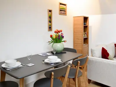 a dining room table with a vase of flowers on it at The Hayloft in Blitterlees