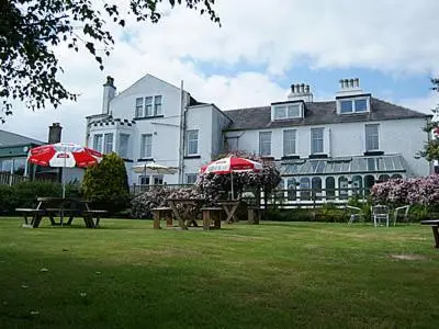a large white house with tables and umbrellas in the grass at The Carradale Hotel in Carradale