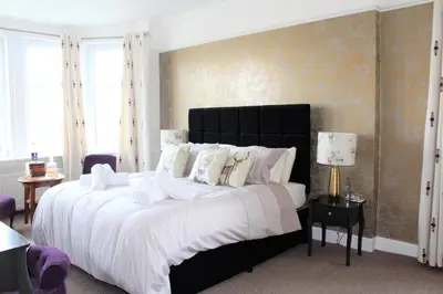 a bedroom with a large bed with white sheets and pillows at The Carradale Hotel in Carradale