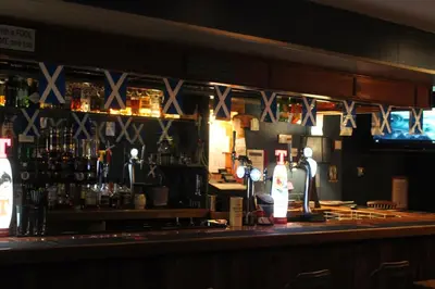 a bar with a counter with bottles of alcohol at The Carradale Hotel in Carradale