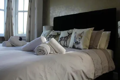 a white bed with towels and pillows on it at The Carradale Hotel in Carradale