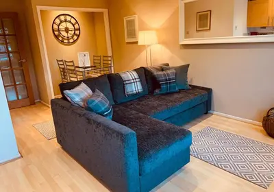 a living room with a blue couch with pillows at The Webstersland Residence in Edinburgh