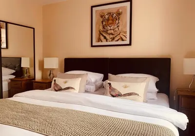 a bedroom with two beds and a picture of a tiger at The Webstersland Residence in Edinburgh