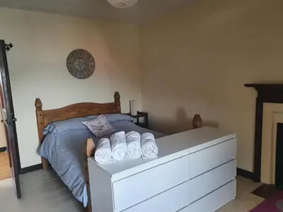 a bedroom with a bed with a white dresser at Argyll Mansions Penthouse in Oban