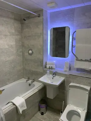 a bathroom with a sink and a toilet and a bath tub at Crowwood Hotel and Alba Restaurant in Chryston