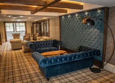 a living room with blue leather couches and a couch at Crowwood Hotel and Alba Restaurant in Chryston