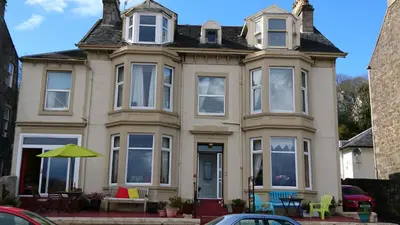 a house with a table and chairs in front of it at Sunnyside House in Rothesay