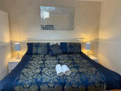 a bedroom with a bed with two slippers on it at Loch Lomond Apartments in Dumbarton