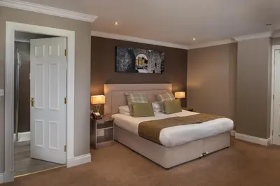 a bedroom with a large bed and two lamps at Fairfield House Hotel in Ayr