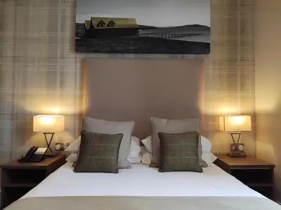 a bedroom with a bed with two lamps and a picture at Fairfield House Hotel in Ayr