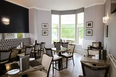 a restaurant with tables and chairs and a window at City Apartments in Glasgow