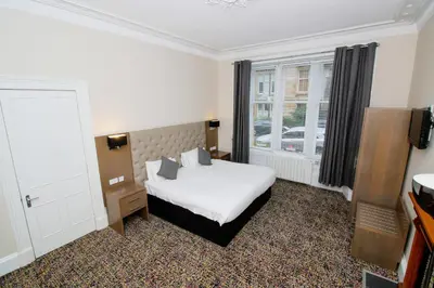 a hotel room with a bed and a window at City Apartments in Glasgow