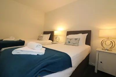 a bedroom with two beds with towels on them at Signature - Douglas View Blantyre in High Blantyre