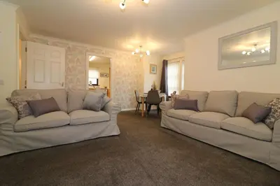a living room with two couches and a dining room at Signature - Douglas View Blantyre in High Blantyre