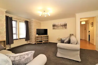 a living room with a couch and a tv at Signature - Douglas View Blantyre in High Blantyre