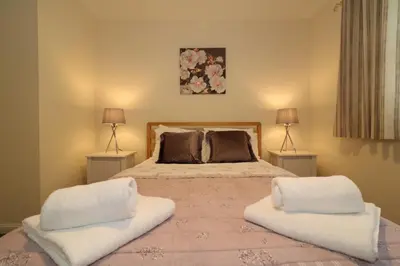 a bedroom with a large bed with two lamps at Signature - Douglas View Blantyre in High Blantyre