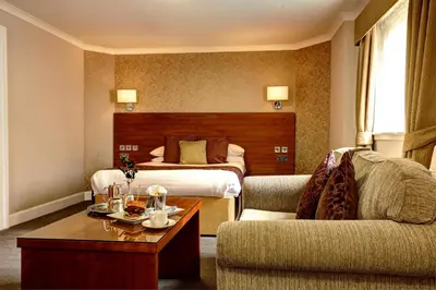 a hotel room with two beds and a couch at Golden Lion Hotel in Stirling