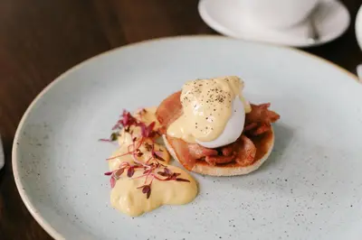 a white plate with a sandwich on a table at Nira Caledonia in Edinburgh