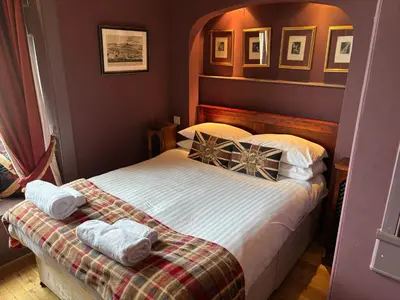 a bedroom with a bed with two towels on it at The Castle Esplanade Residence in Edinburgh