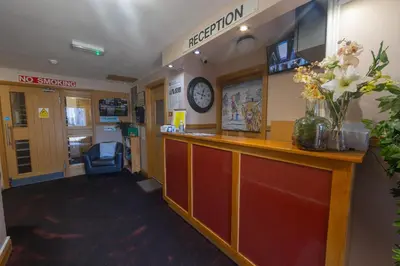 a waiting room with a reception counter with a vase of flowers at Quay Head View Aparthotel in Stranraer