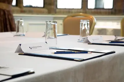 a table with pens and notebooks on top at Western House Hotel At Ayr Racecourse in Ayr