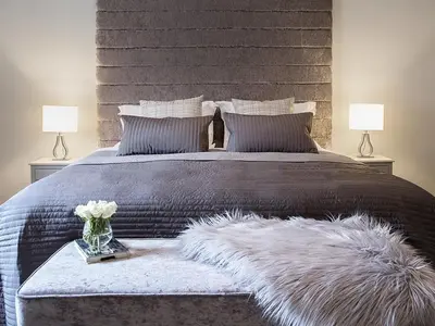 a bedroom with a large bed with a furry blanket and two lamps at The Lane Hotel in Edinburgh