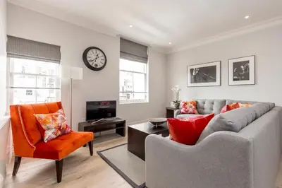 a living room with a couch and a tv at Destiny Scotland - Chisholm Hunter Suites in Edinburgh