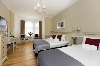 a hotel room with two beds and a desk at The Haymarket Hotel in Edinburgh